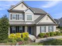 Inviting two-story home with a beautiful front yard featuring mature landscaping and a welcoming blue front door at 1010 Smoke Willow Way, Rolesville, NC 27571