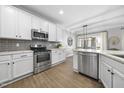 Modern kitchen with stainless steel appliances, quartz countertops, and white cabinets at 1010 Smoke Willow Way, Rolesville, NC 27571