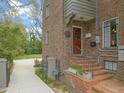 Brick home featuring a red front door and brick steps leading up to the entrance, with a long driveway and landscaped yard at 1024 W Markham Ave, Durham, NC 27701