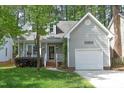 Inviting exterior of home with attached garage, complemented by lush landscaping and a charming facade at 104 Silver Fox Ct, Cary, NC 27511
