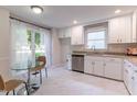Kitchen with white cabinets, stainless steel appliances, granite countertops and a glass table near a bright window at 104 Silver Fox Ct, Cary, NC 27511