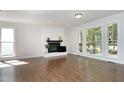 Spacious living room with hardwood floors, fireplace, and large windows offering natural light and outdoor views at 104 Silver Fox Ct, Cary, NC 27511