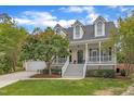 Inviting two-story home with a classic front porch, lush lawn, and a convenient two car garage at 106 Kenneil Ct, Apex, NC 27502
