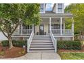Close up of the house entrance showing the steps to the columned front porch with mature landscaping at 106 Kenneil Ct, Apex, NC 27502