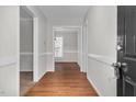 Bright hallway featuring hardwood floors, neutral paint, and doorway views into carpeted and dining areas at 1100 Brandywine Ln, Rocky Mount, NC 27804