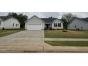 Lovely single-story home with gray siding, two-car garage, concrete driveway, and sidewalk at 115 Oakfield Trace Dr, Four Oaks, NC 27524