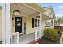 Inviting front porch with decorative wreath, planters, and charming welcome sign at 1202 Lexington Ridge Ln, Apex, NC 27502