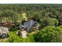 Aerial view of a luxury home with mature trees, golf course and beautiful landscaping at 1317 Colonial Club Rd, Wake Forest, NC 27587