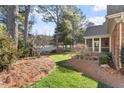 Lush backyard featuring a mix of green grass and landscaped areas, with a glimpse of a screened porch at 1317 Colonial Club Rd, Wake Forest, NC 27587