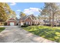 Long driveway leading to a brick home with a well-maintained lawn and mature trees at 1317 Colonial Club Rd, Wake Forest, NC 27587