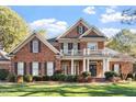 Charming two-story brick home with a welcoming front porch and meticulously maintained landscaping at 1317 Colonial Club Rd, Wake Forest, NC 27587