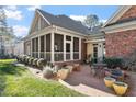 Outdoor patio with brick flooring, surrounded by potted plants and a screened porch at 1317 Colonial Club Rd, Wake Forest, NC 27587