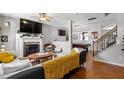 Open-concept living room featuring hardwood floors, fireplace, and seamless flow to recreation area at 1322 Regulator St, Raleigh, NC 27603