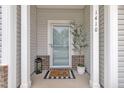 Inviting front porch features white columns, a storm door and a charming welcome mat at 1410 Arena Ln, Fuquay Varina, NC 27526