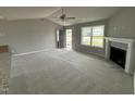 Spacious living room with gray walls, plush carpet, and a cozy fireplace with mantel at 146 Starry Sky Dr, Benson, NC 27504