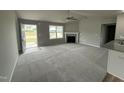 Bright living room with a fireplace, grey walls, carpet and large window with natural light at 146 Starry Sky Dr, Benson, NC 27504
