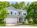 Charming two-story home featuring a two-car garage and a cozy front porch with inviting rocking chairs at 15 White Spruce Ct, Durham, NC 27703