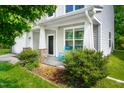 Inviting front porch with blue rocking chairs, stone accents, and manicured landscaping at 15 White Spruce Ct, Durham, NC 27703