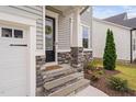 Charming front entrance featuring stone accents, a welcoming wreath, and well-maintained landscaping at 1711 Sandoval Dr, Durham, NC 27703