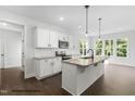 Bright, open kitchen with a large island, white cabinetry, and modern fixtures at 200 Pretty Run Branch Ln, Wendell, NC 27591