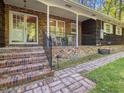 Inviting brick porch with classic rocking chairs and decorative railing, offering a relaxing outdoor space at 203 Wood Cir, Chapel Hill, NC 27514