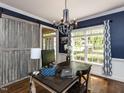 Stylish home office with a barn door, large windows, and modern chandelier, perfect for working from home at 204 Flint Point Ln, Holly Springs, NC 27540