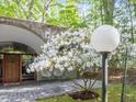 Arched entrance with blooming tree, featuring a wreath and seating area at 205 Wood Cir, Chapel Hill, NC 27514