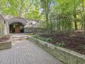 Modern home exterior with arched entryway and landscaped garden in a lush, wooded setting at 205 Wood Cir, Chapel Hill, NC 27514