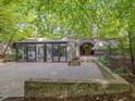 Unique modern home with concrete facade and glass, surrounded by mature trees and greenery at 205 Wood Cir, Chapel Hill, NC 27514