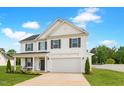 Charming two-story home features white siding, black shutters, covered porch, and attached two car garage at 214 Thumper Way, Clayton, NC 27520
