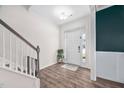 Bright foyer with hardwood floors, white walls, staircase, and front door with glass sidelights at 214 Thumper Way, Clayton, NC 27520