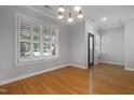Bright living area featuring gleaming hardwood floors and plantation shutters at 2157 Dunn Rd, Raleigh, NC 27614