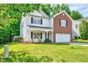 Well-kept home with a green lawn, landscaping, and two-car garage; perfect curb appeal at 217 Carolina Town Ln, Holly Springs, NC 27540