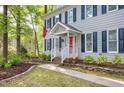 The exterior of the grey two-story home has dark shutters and landscaped front yard with walkway at 2205 Long And Winding Rd, Raleigh, NC 27603