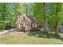 Quaint home with brick facade, surrounded by mature trees and green lawn at 224 Heidinger Dr, Cary, NC 27511
