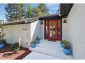 Close up of the red front door and entrance with potted plants at 226 Smith Dr, Durham, NC 27712