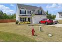 Two-story home with landscaped yard, attached garage, and driveway featuring two parked cars at 227 Sumter Ct, Burlington, NC 27217