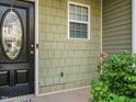 Close-up of the front entrance, showing the green shingle siding and a classic black door with oval glass at 23 Great View Ct, Clayton, NC 27527
