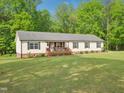 Inviting one-story home with well maintained lawn, a front porch, and surrounded by green trees at 2705 Flat Rock Rd, Franklinton, NC 27525