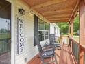 Cozy front porch featuring rocking chairs, wooden floors, and charming string lights for relaxing outdoors at 2705 Flat Rock Rd, Franklinton, NC 27525