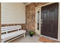 Cozy front porch featuring stone accents, a white bench, and decorative plants at 2728 Evanston Ave, Durham, NC 27703