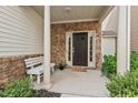 Inviting front porch with stone accents, a white bench, and lush greenery at 2728 Evanston Ave, Durham, NC 27703
