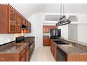 Well-equipped kitchen featuring wooden cabinetry, black appliances, and ample counter space at 300 Ravenstone Dr, Cary, NC 27518