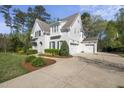 Wide driveway leading to a charming white brick home with a three-car garage and manicured landscaping at 3138 Curling Creek Dr, Apex, NC 27502