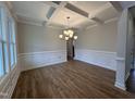 Elegant dining room featuring hardwood floors, detailed trim work, coffered ceiling, and a modern chandelier at 3529 Bailey Lake Dr, Fuquay Varina, NC 27526