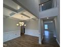 Elegant dining room featuring hardwood floors, detailed trim work, coffered ceiling, and a modern chandelier at 3529 Bailey Lake Dr, Fuquay Varina, NC 27526