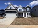 Beautiful new two-story home with a white trim, dark blue siding and an attached two-car garage at 3529 Bailey Lake Dr, Fuquay Varina, NC 27526