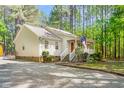 Quaint single-story home featuring a covered porch, tidy landscaping, and a gravel driveway at 3607 Springhollow Ct, Efland, NC 27243