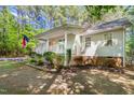 Lovely home with a cozy front porch, surrounded by green bushes and mature trees at 3607 Springhollow Ct, Efland, NC 27243