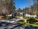 Gated entrance to a luxurious property with a long driveway, lush landscaping, and secure wrought iron gate at 464 Rosemont Dr, Durham, NC 27713